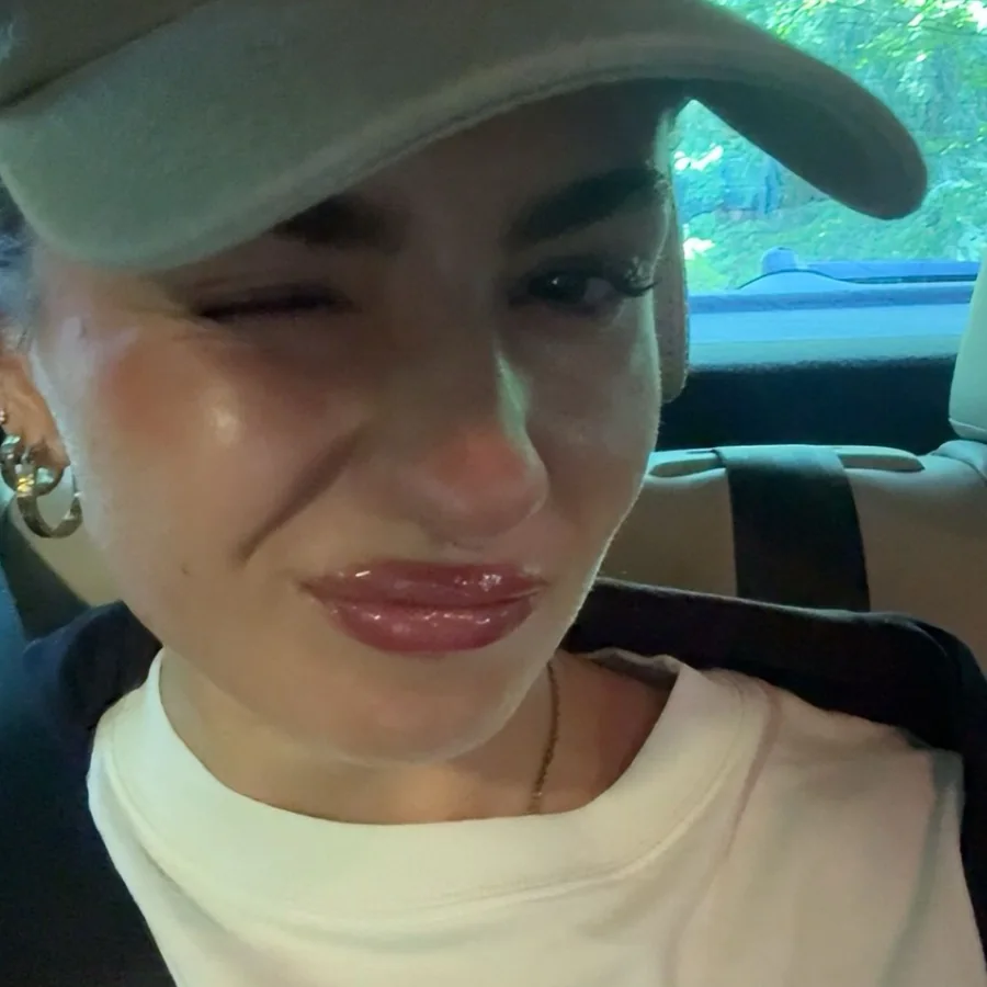 Marie, die Gründerin von Rierieprints, mit Cap im Auto, zwinkert in die Kamera